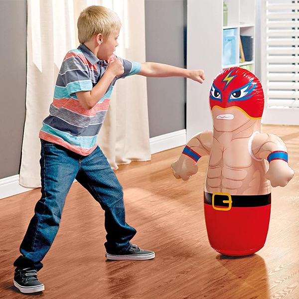 Child punching and playing with INTEX inflatable bop bag toy indoors